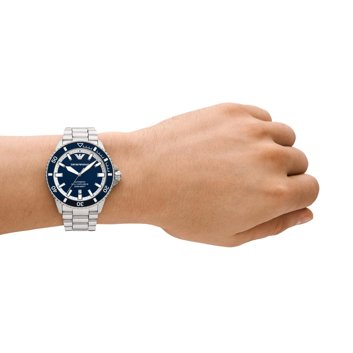 Hand wearing a silver watch with a blue face on a white background
