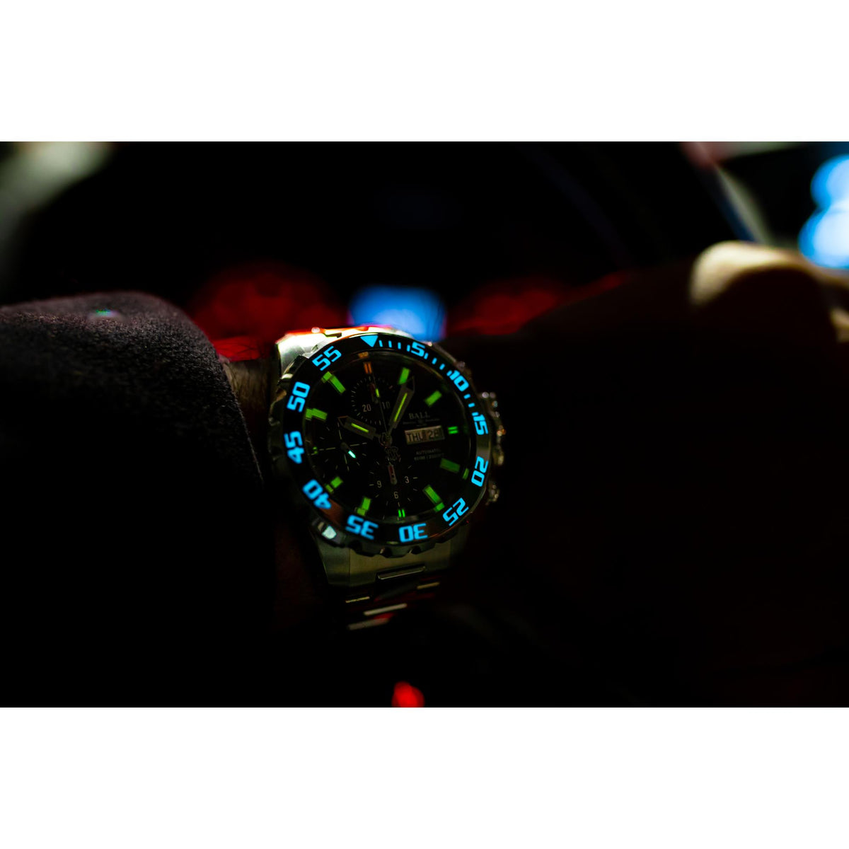 Men's diver watch close-up with black dial and green glowing bezel markings