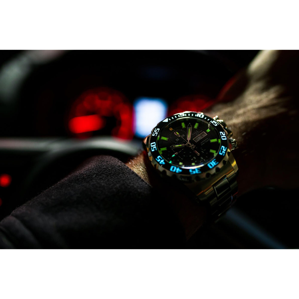 Men's diver watch close-up with black dial and neon green glowing bezel numerals