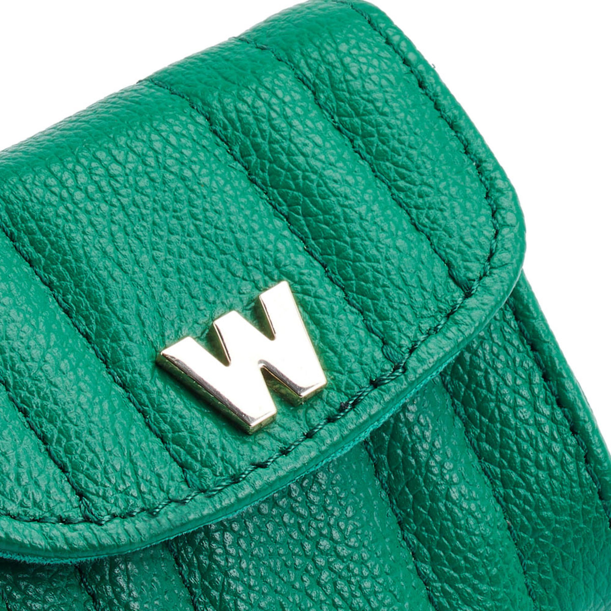 Close-up of green leather earbud case flap with gold W logo and stitching.