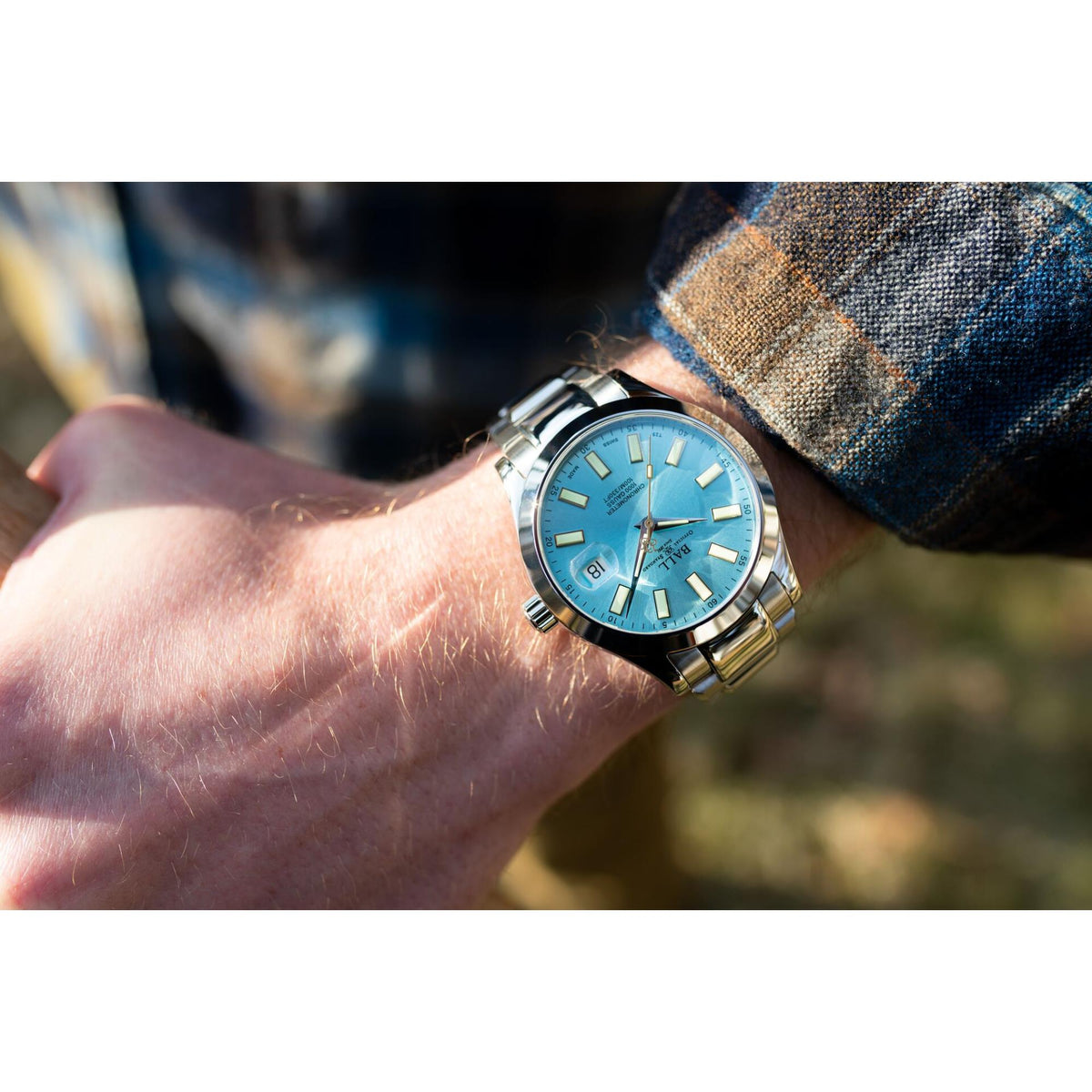 Men’s stainless steel watch on wrist, ice blue dial with metal bracelet