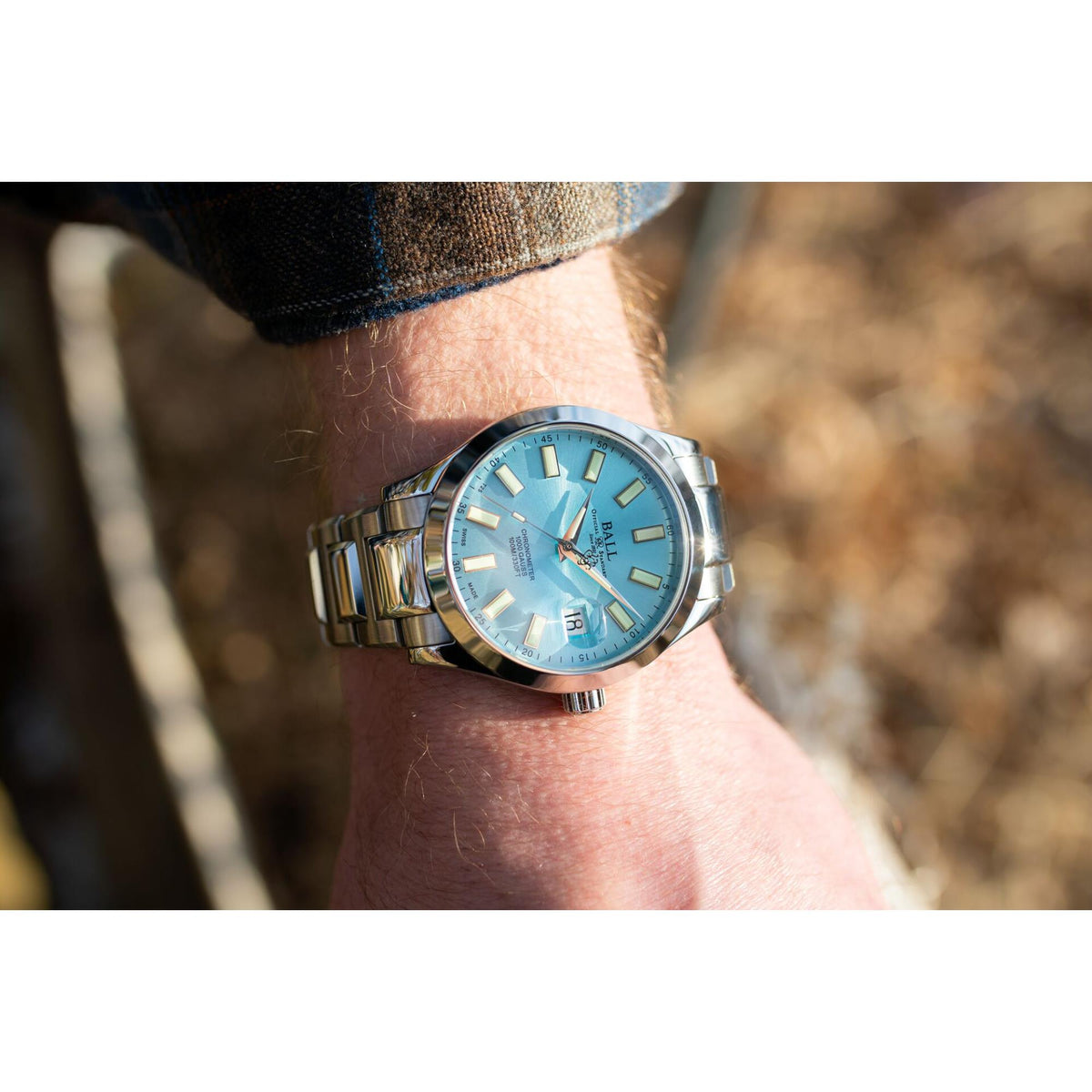 Men’s stainless steel watch on wrist, ice blue dial with date display