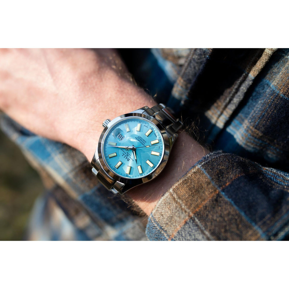 Ice blue dial stainless steel chronometer-style men’s watch on wrist, full case and lugs shown