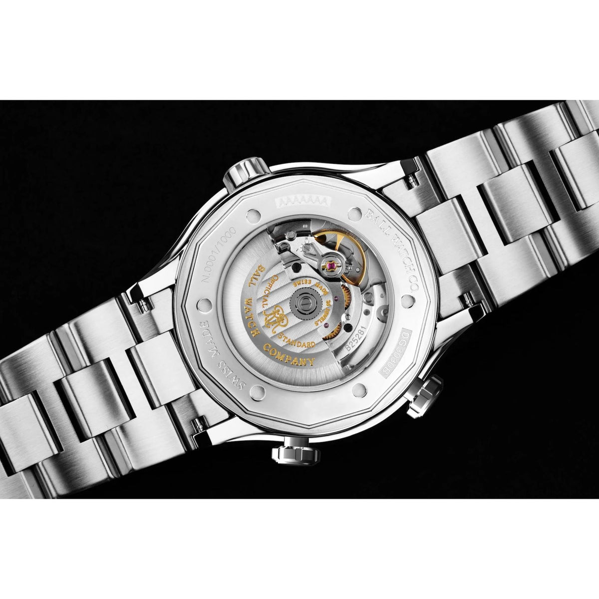 Steel watch caseback with visible movement and metal bracelet