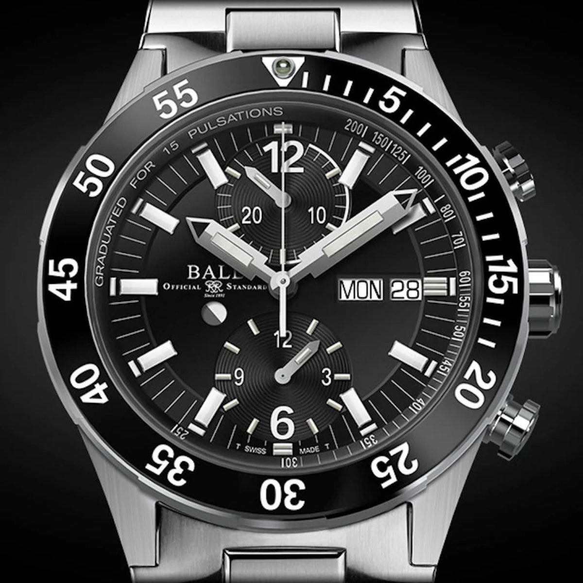 Close-up of black chronograph dial with silver hands, subdials, and MON 28 date window