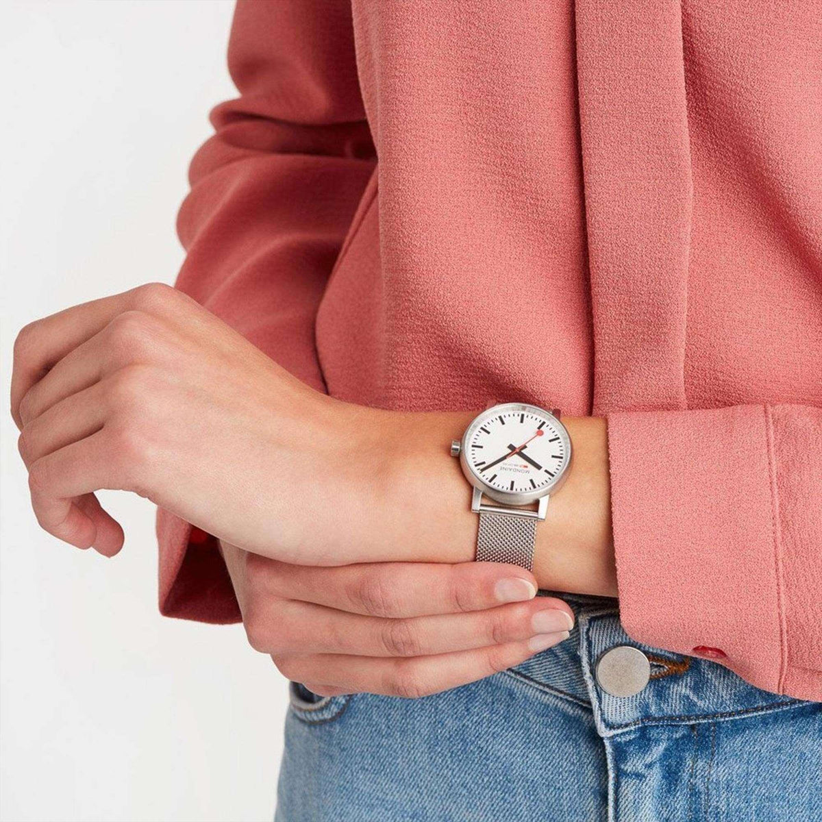 On-wrist lifestyle shot of Mondaine Evo2 MSE.35110.SM classic station watch worn with a shirt and jeans