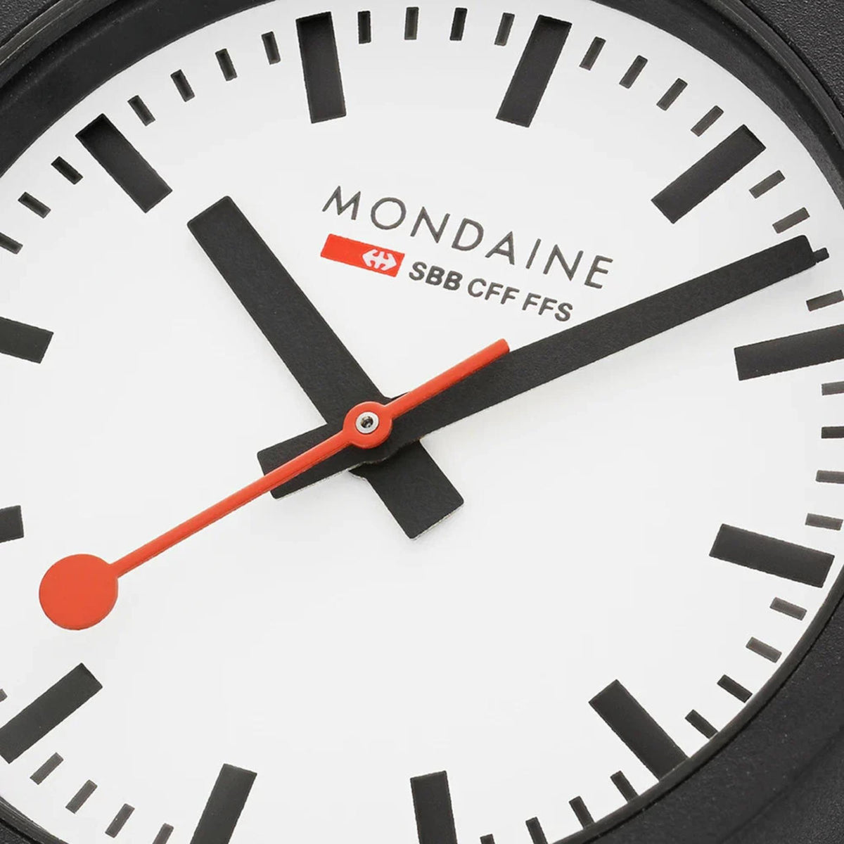 Close-up of quartz watch white dial with black markers and orange second hand