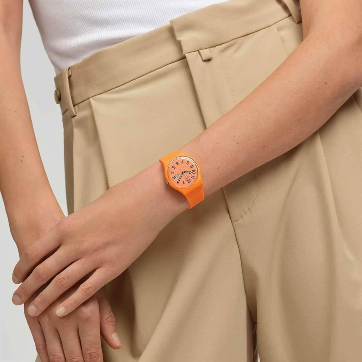 Orange silicone strap watch on wrist, orange dial with numeral markers and date