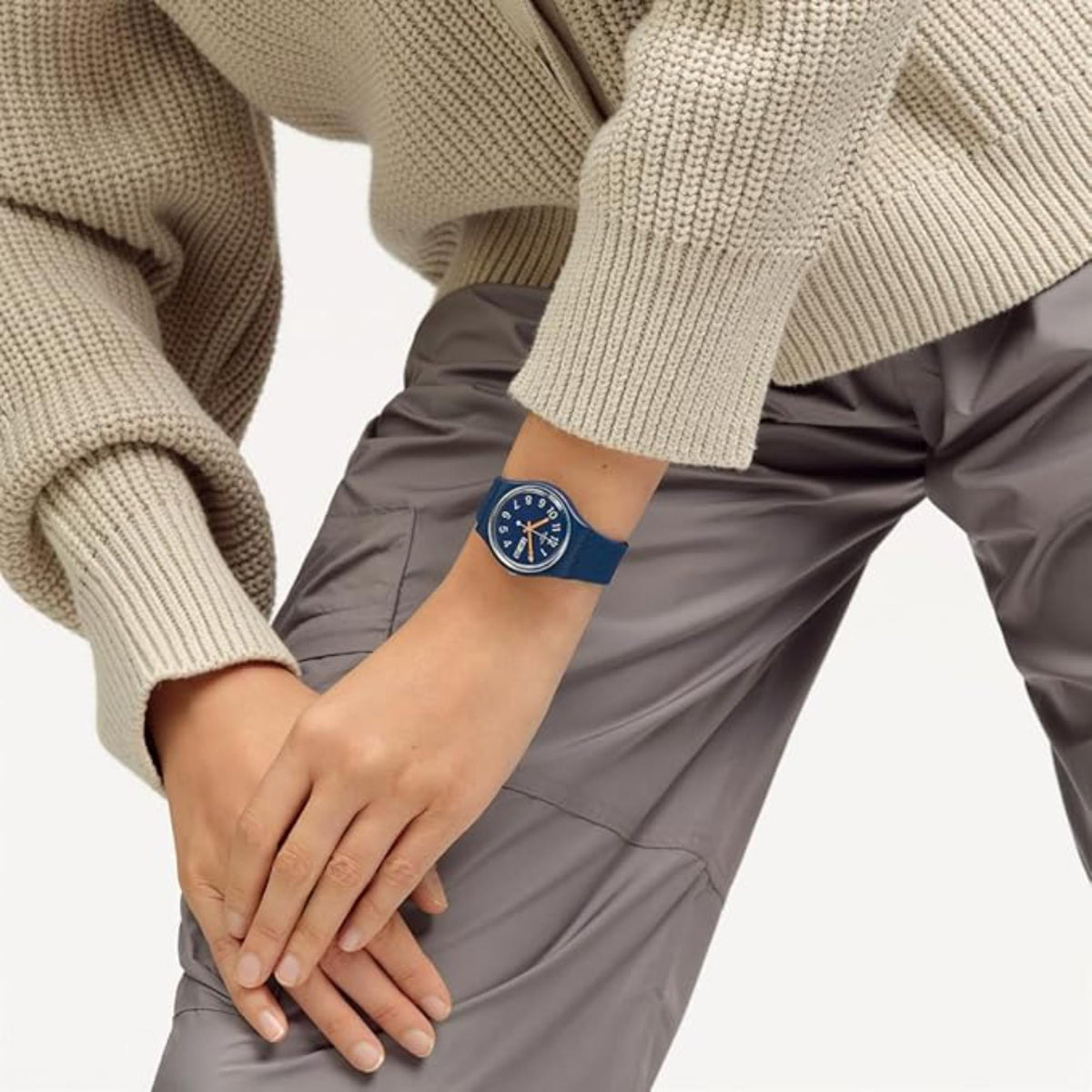 Silicone watch on wrist, blue dial with orange markers and date window