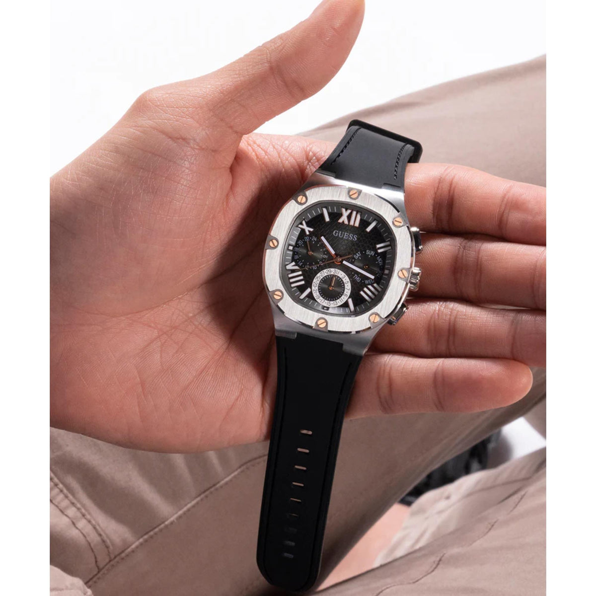 Men's textured dial watch worn on wrist, black silicone strap and silver case