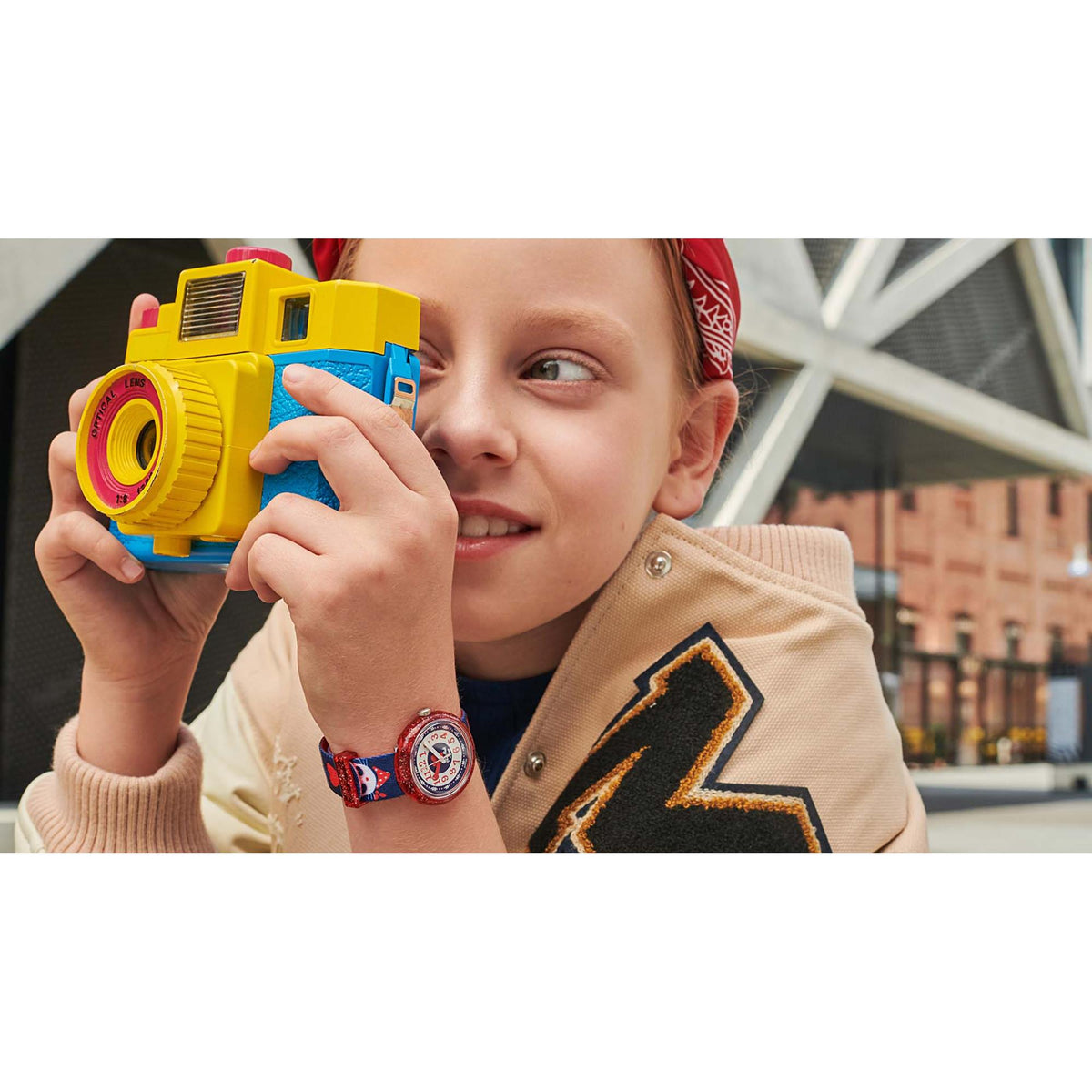 Child holding a toy while wearing a red and blue cat kids watch