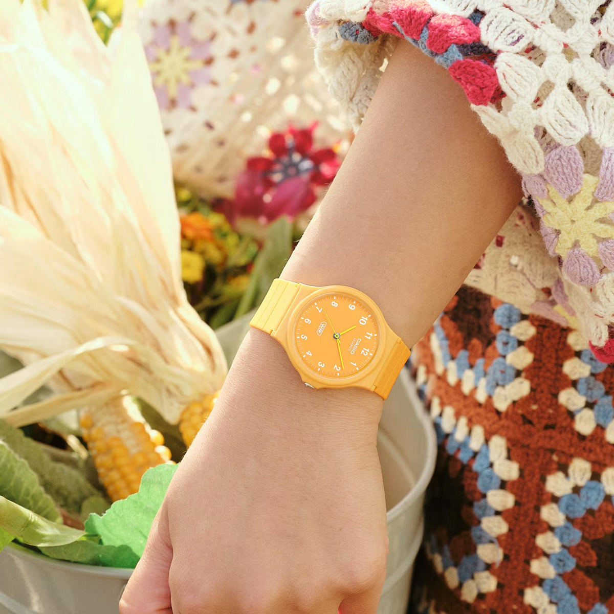 Orange resin strap analog watch on wrist, orange dial with white hour markers