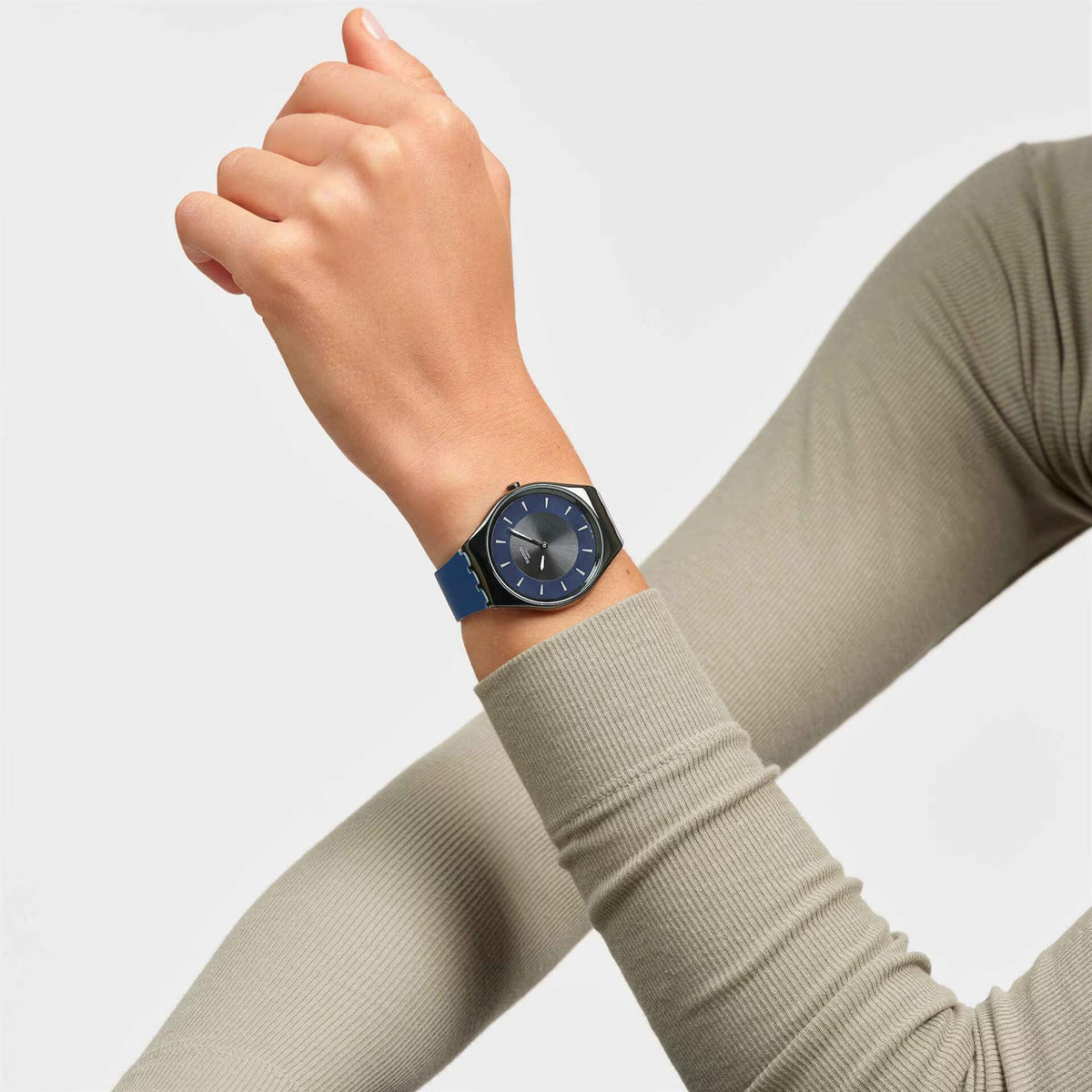 Swatch silicone watch on wrist with blue strap and dark blue dial