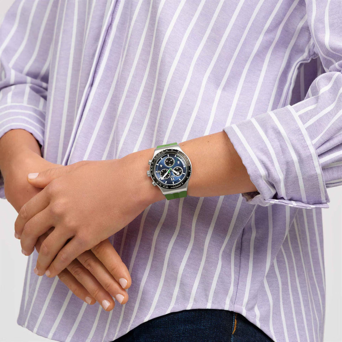 Swatch silicone watch on wrist, blue dial and green strap with silver bezel