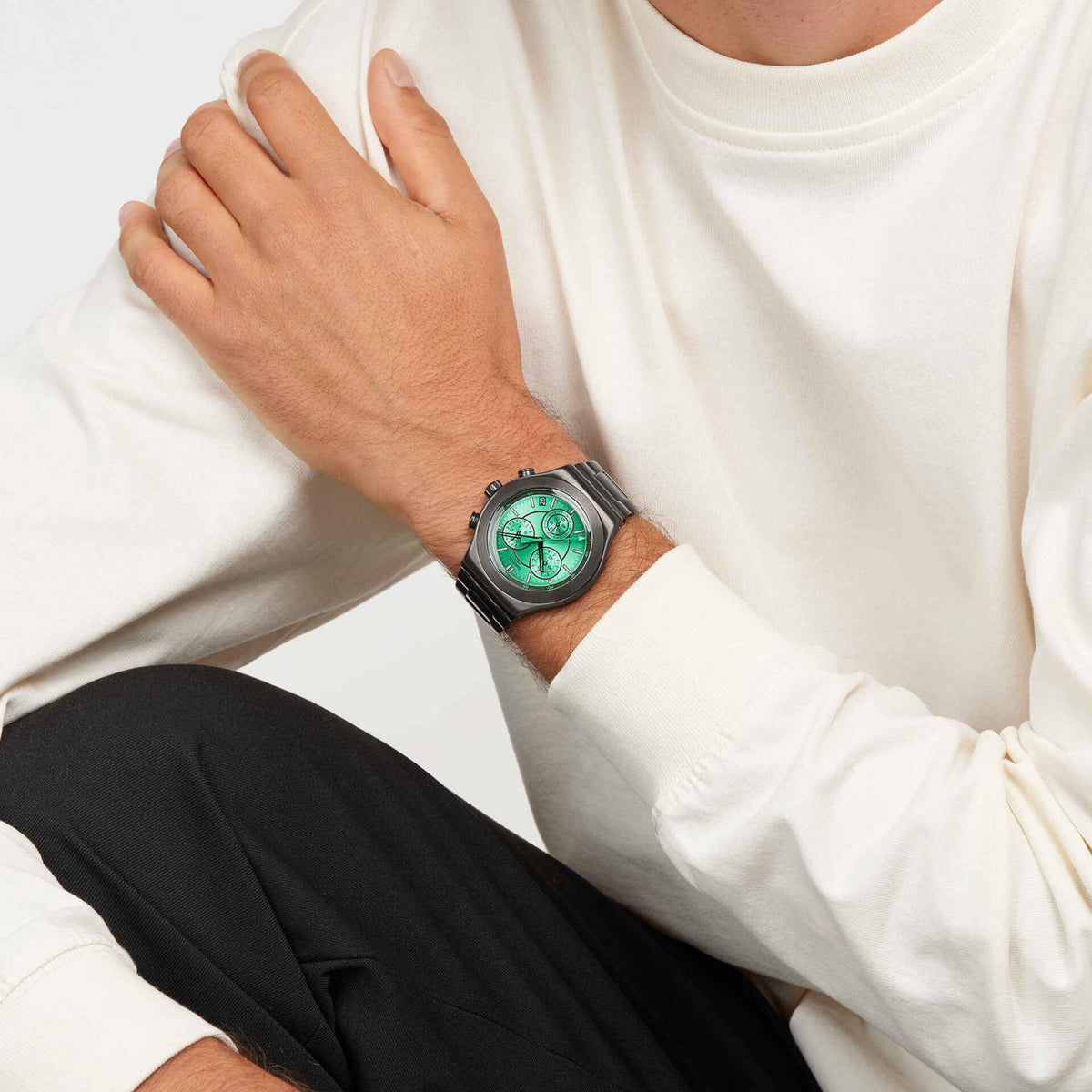Swatch wristwatch on wrist with dark steel bracelet and vivid green round dial