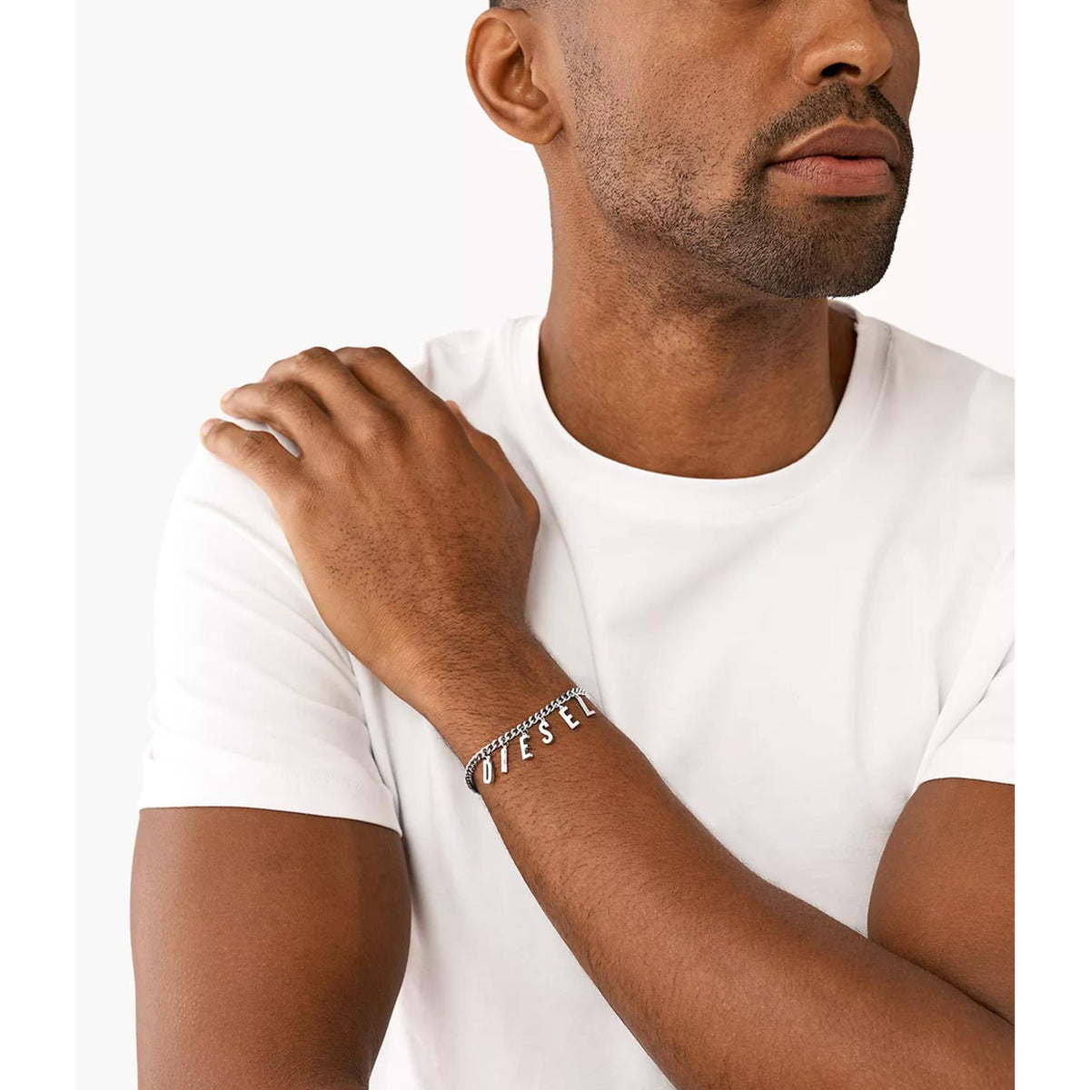 Stainless steel chain bracelet worn on arm with letter charms and open clasp, silver tone