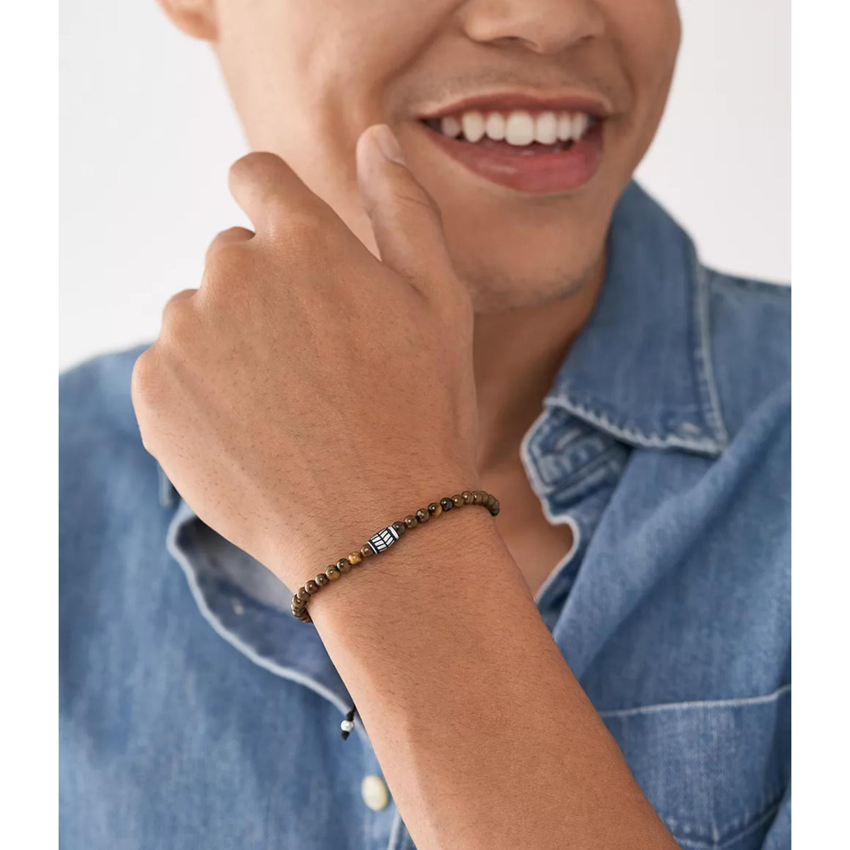 Men's brown bead bracelet with black cord and metal clasp worn on wrist