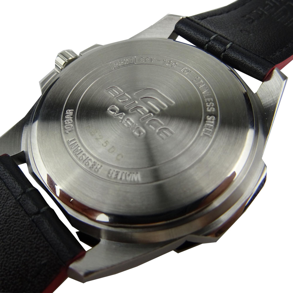 Stainless steel watch caseback with engraved markings, black leather strap