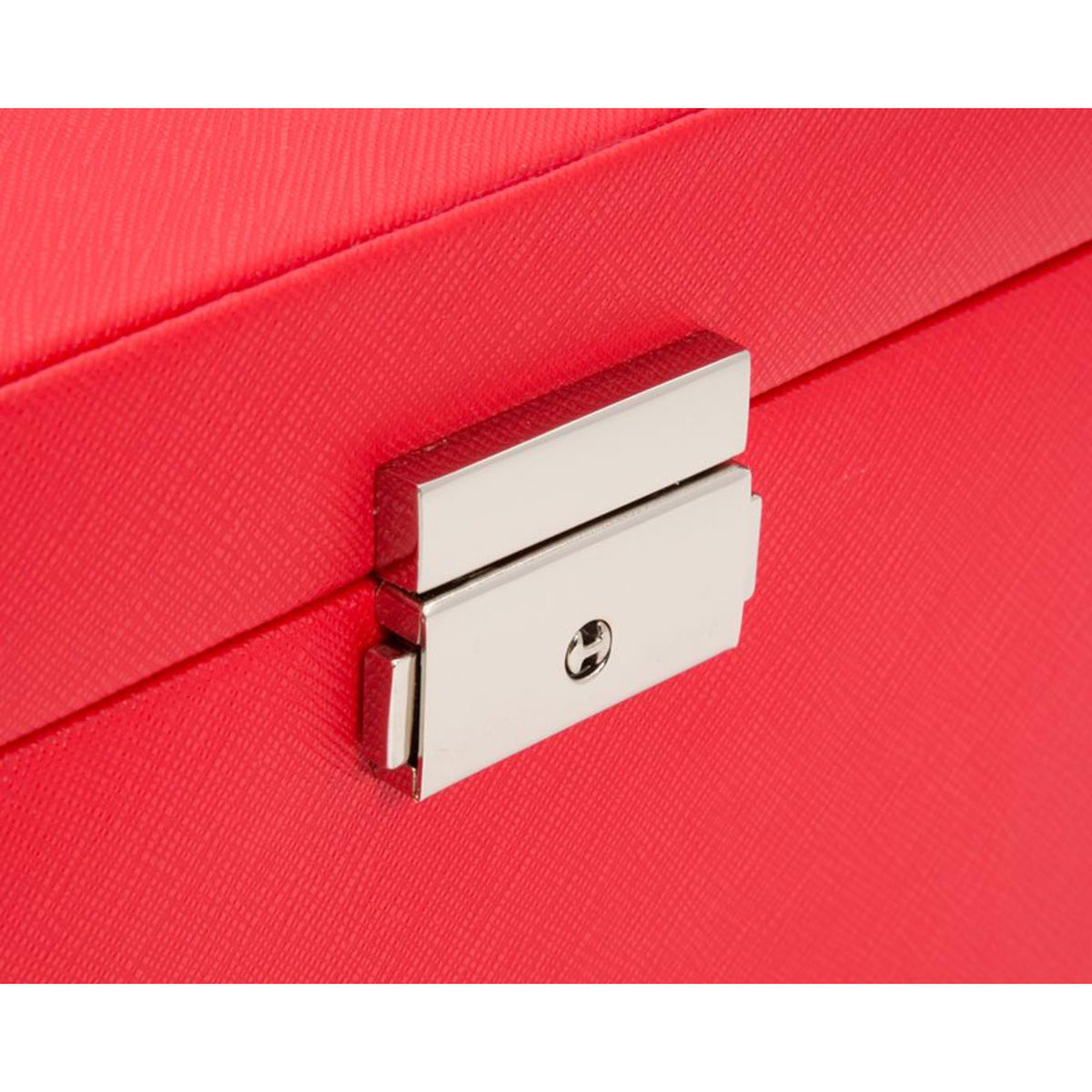 Close-up of red jewelry box clasp with engraved emblem