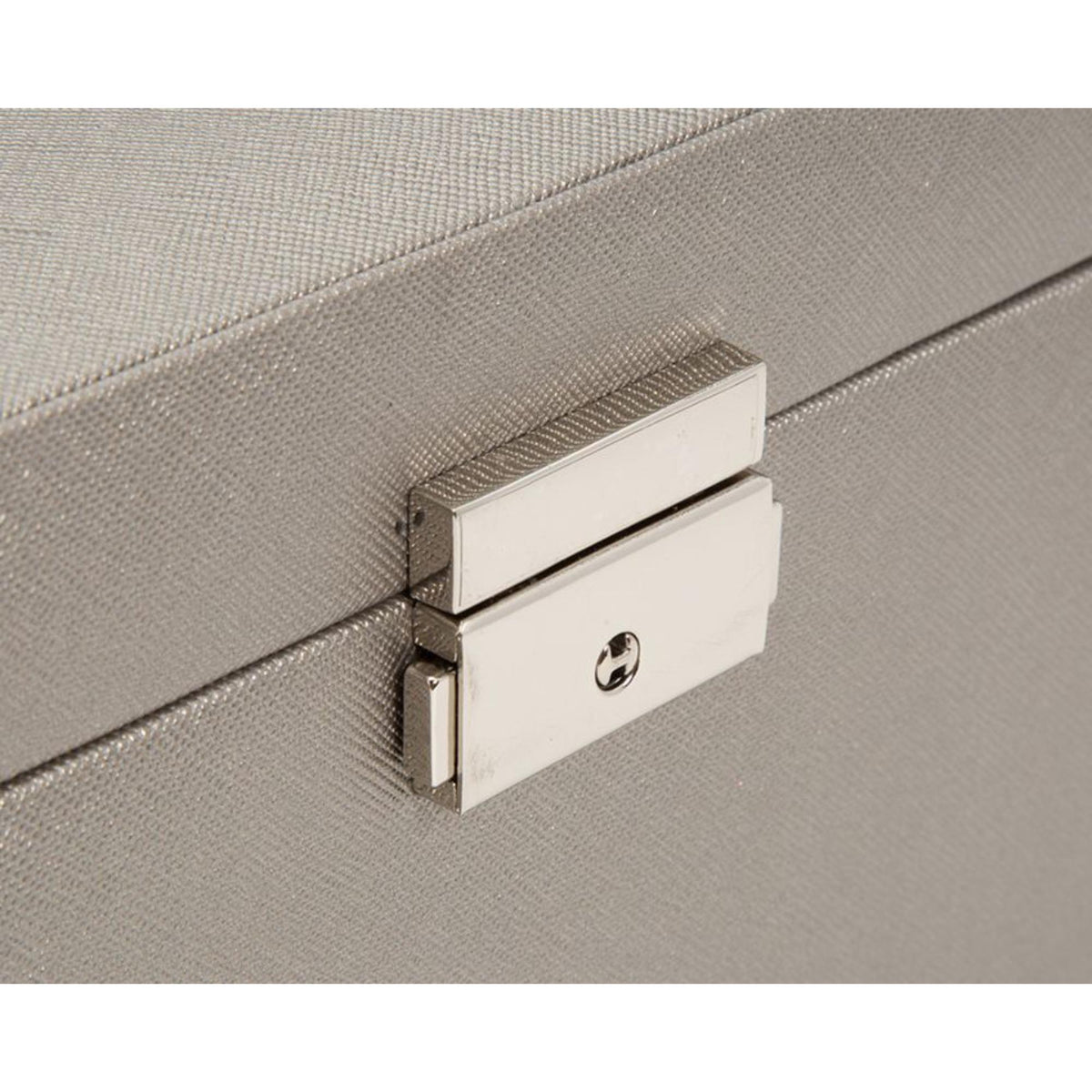 Large jewelry box latch and metal emblem on tan leather front panel