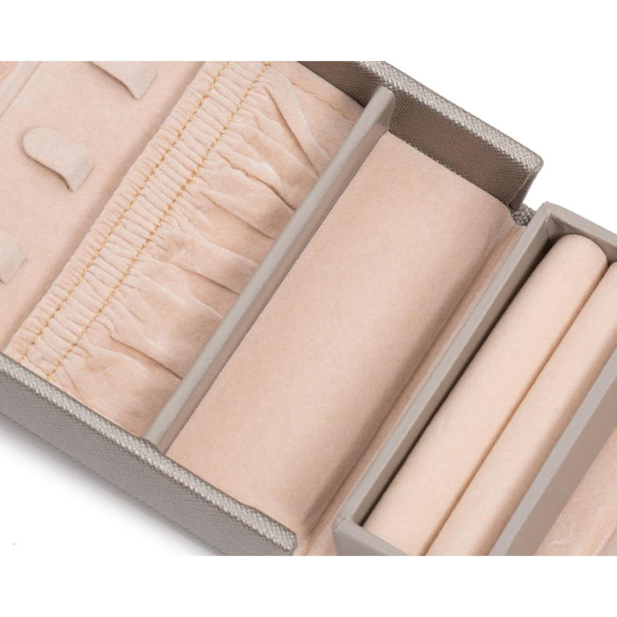 Fold-out jewelry box interior close-up with cushioned compartments and divider panels, tan