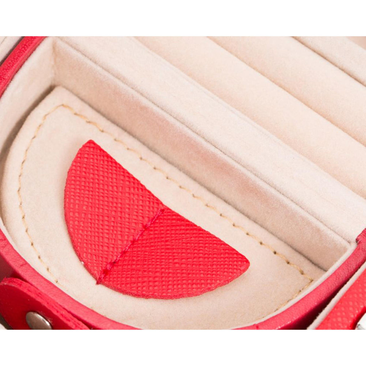 Close-up of red lined interior with a textured inlay and stitched beige backing.