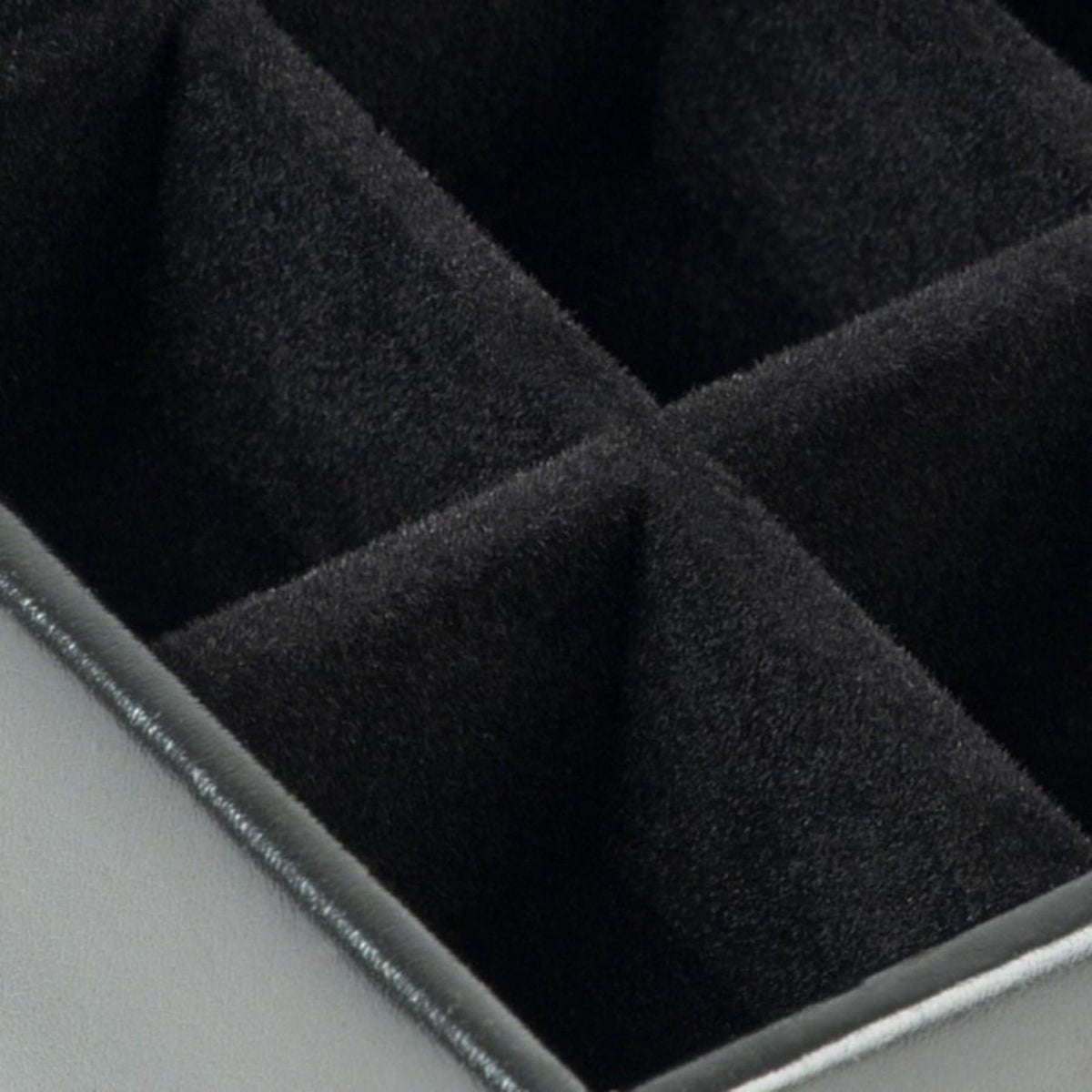 Black fabric-lined cufflink box insert with cushioned padded sections