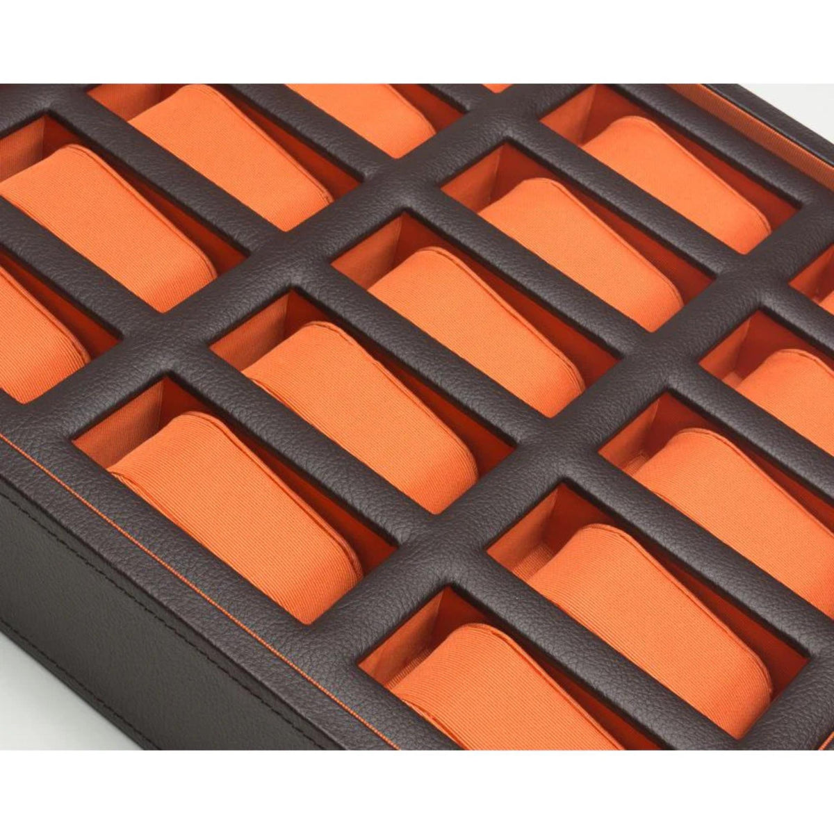 Close-up of dark grid watch holders with orange padded inserts inside the box