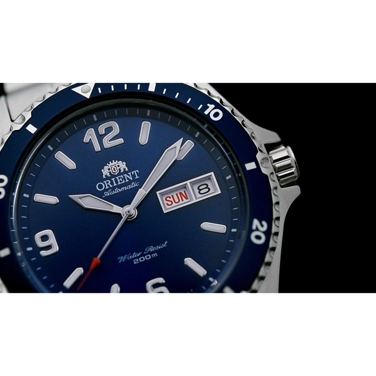 Men's automatic watch close-up of blue dial, day/date window, and bezel minute markers