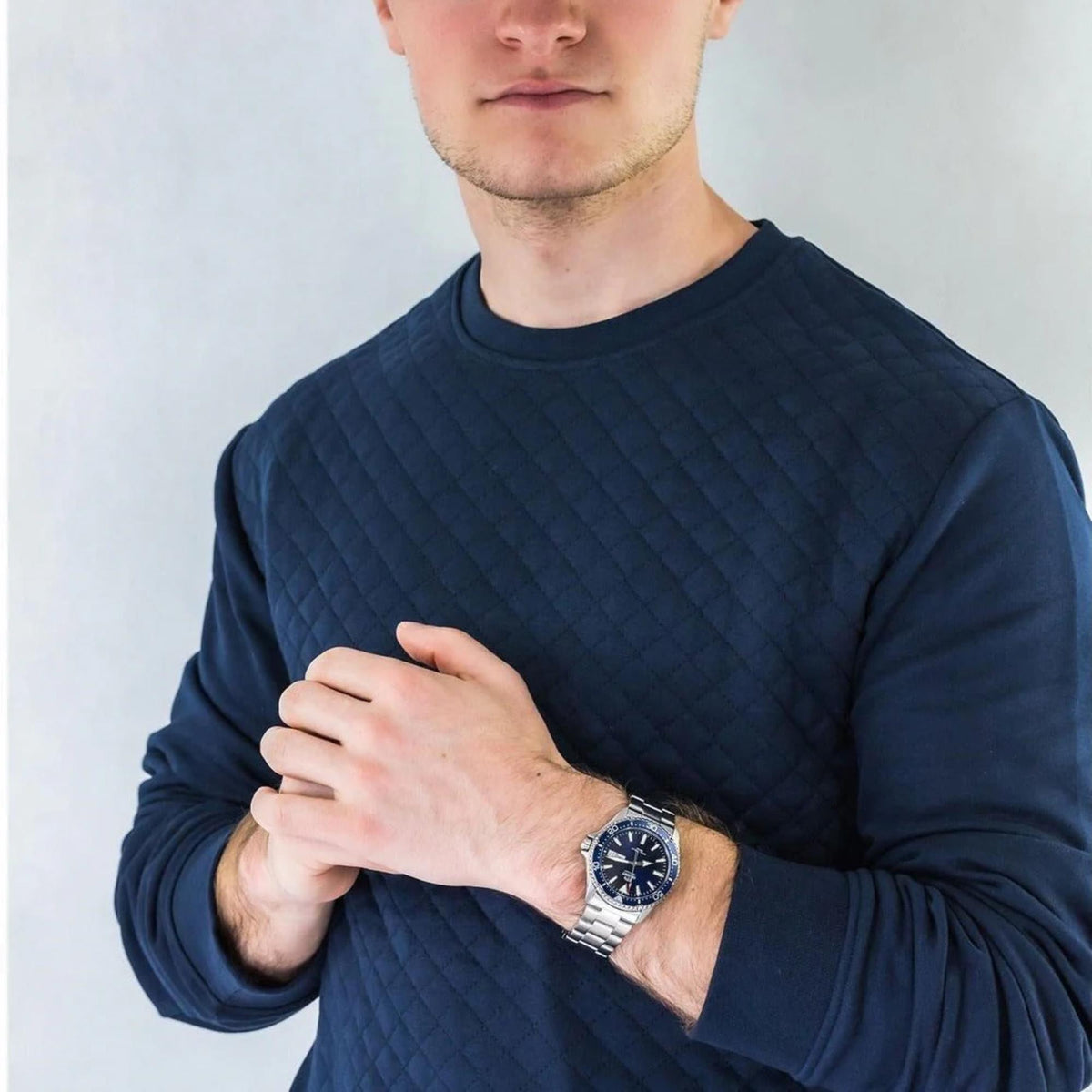 A man wearing a  blue Orient Mako automatic watch on his wrist.