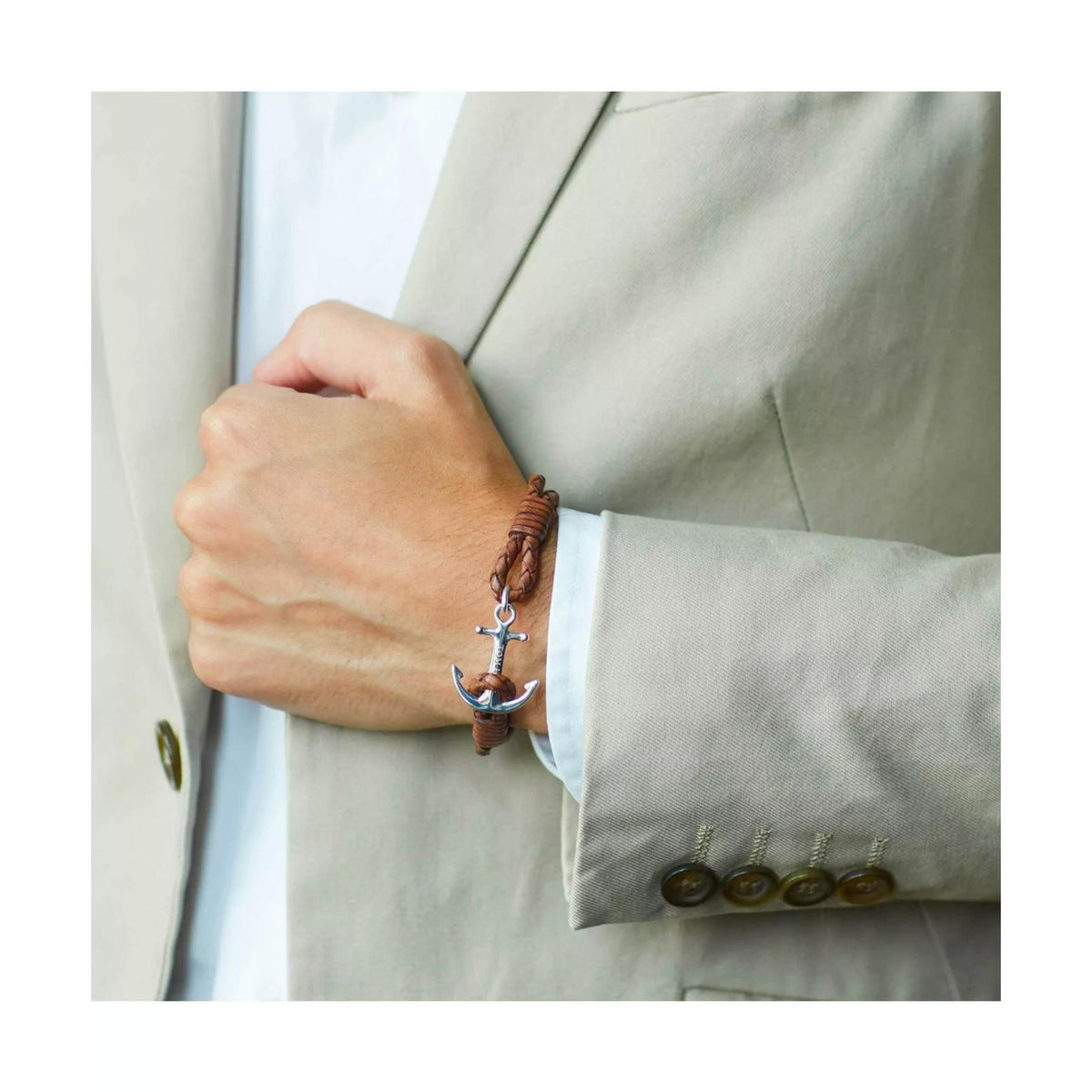 Brown braided anchor bracelet on wrist with silver anchor charm