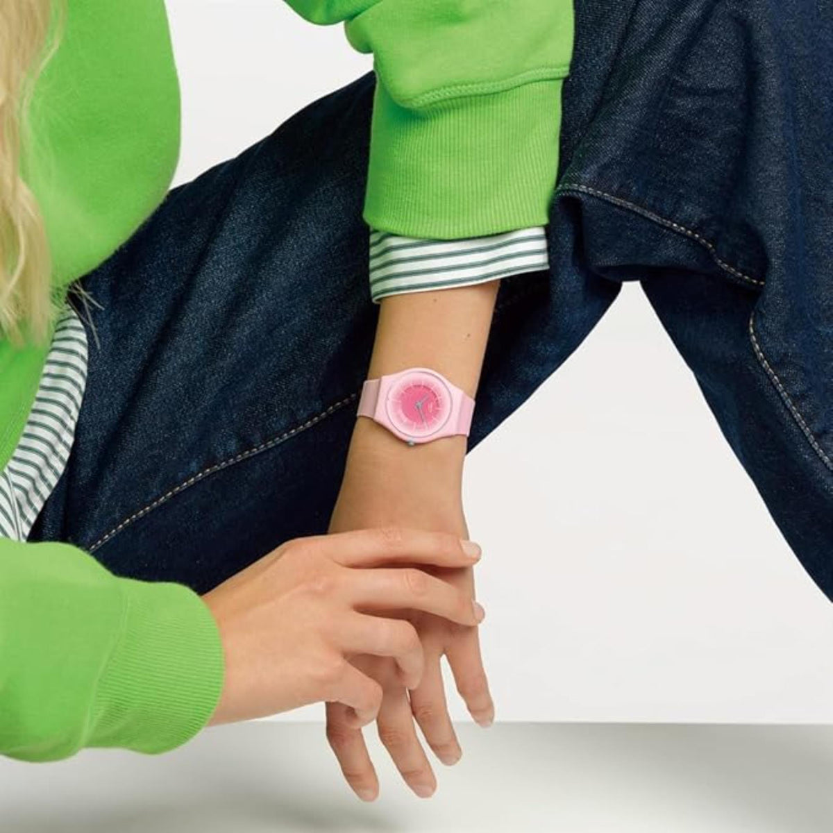 Pink Swatch quartz wristwatch on wrist, pink dial and silicone band