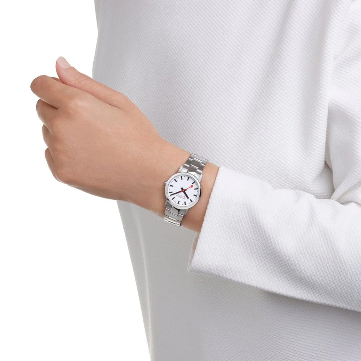 Ladies steel quartz watch on wrist with white dial and red hands, polished bracelet