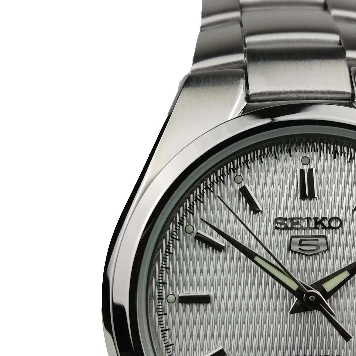 Top section detail of Seiko 5 SNK601K1 mens watch showcasing the polished bezel and white dial