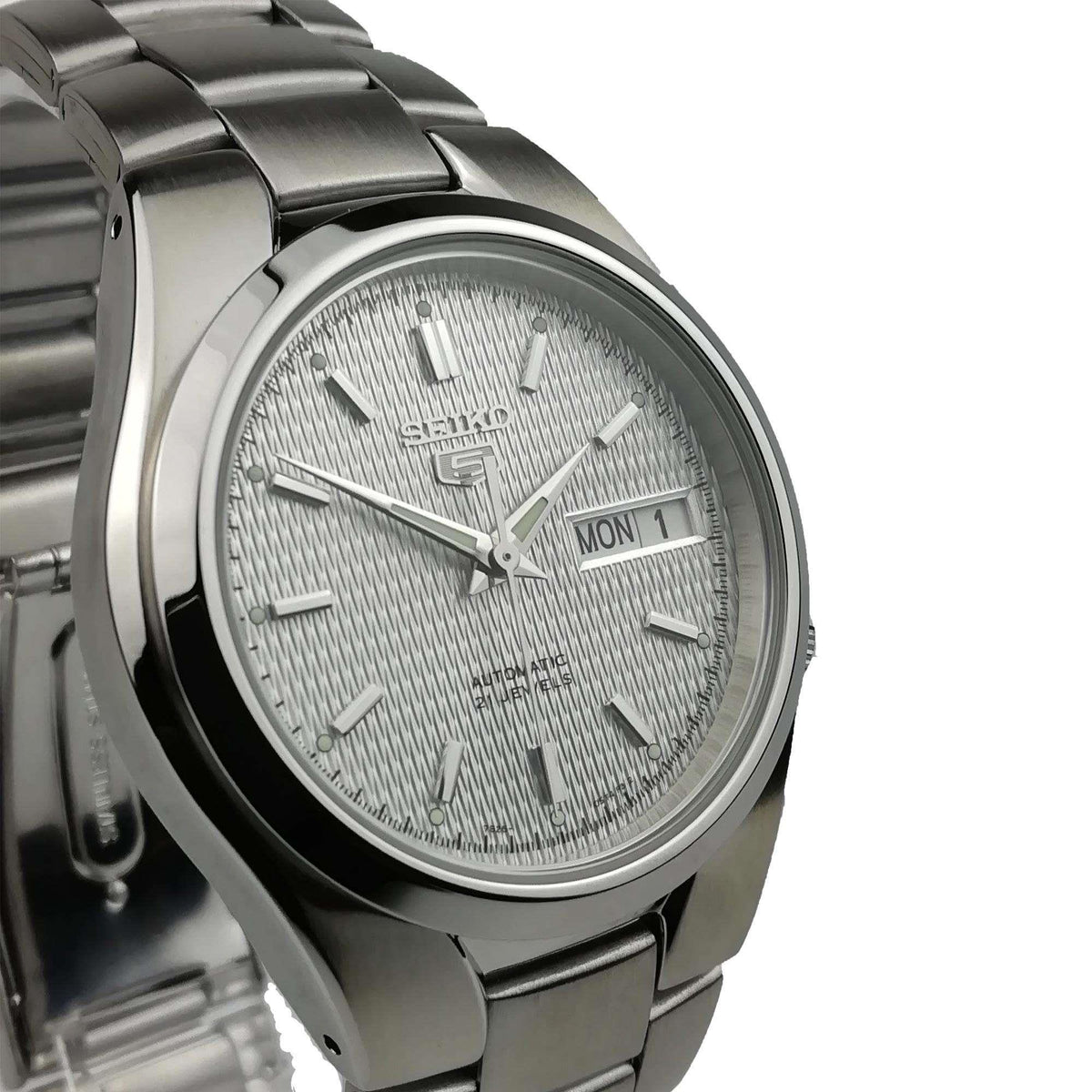 Perspective view of Seiko 5 SNK601K1 mens watch displaying the brushed steel case and textured white dial