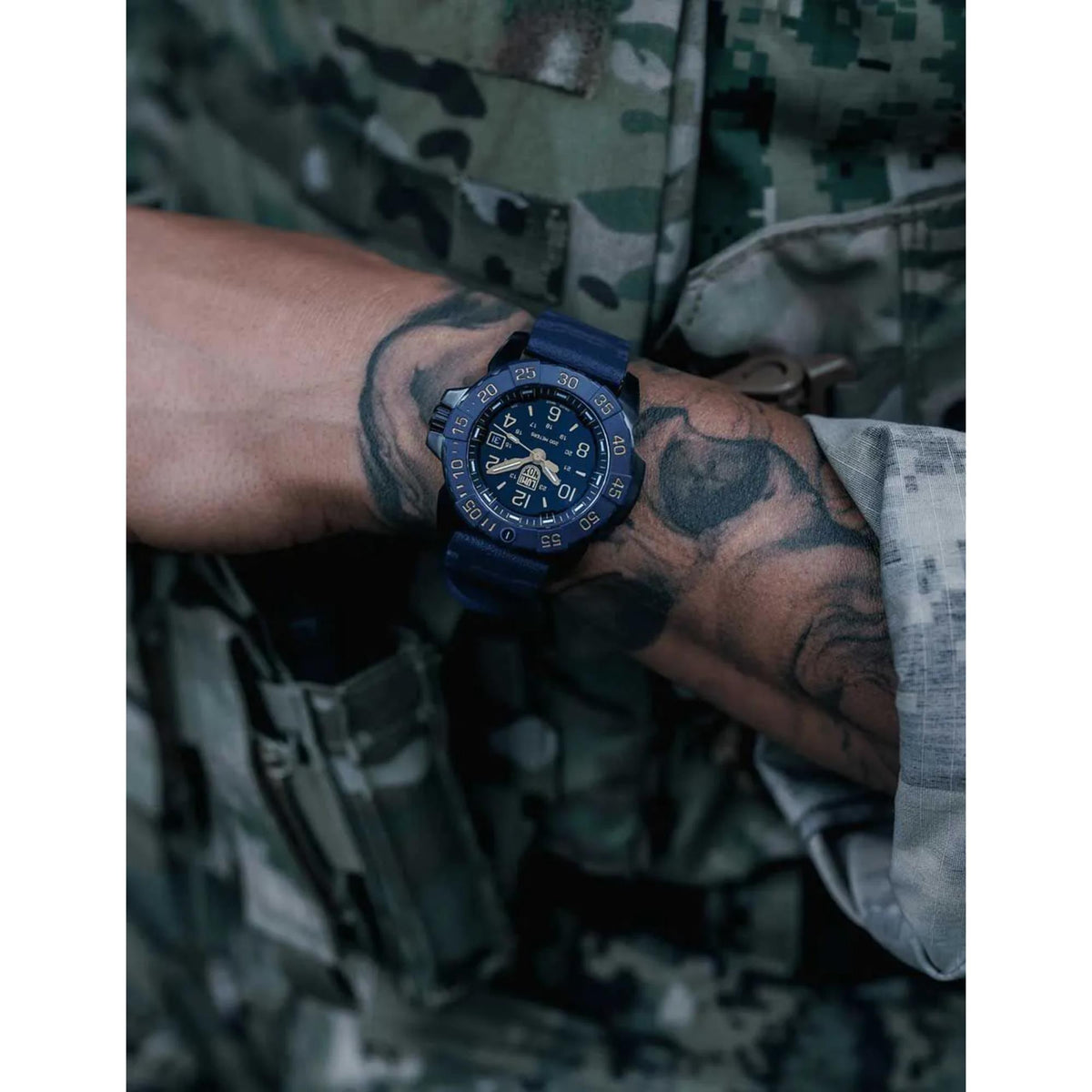 Navy Seal men's quartz watch on wrist with blue rubber strap and black dial.