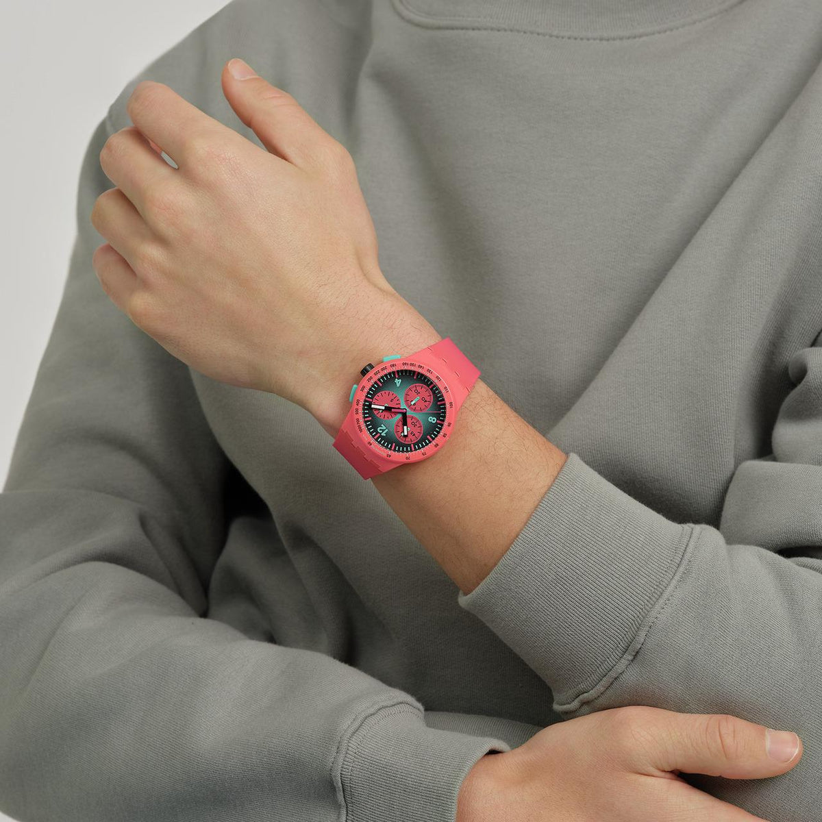 Silicone strap watch on wrist; red case and dial with three subdials, black hands