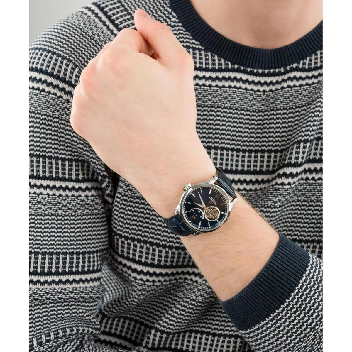 Men's automatic watch with blue dial and black leather strap on wrist