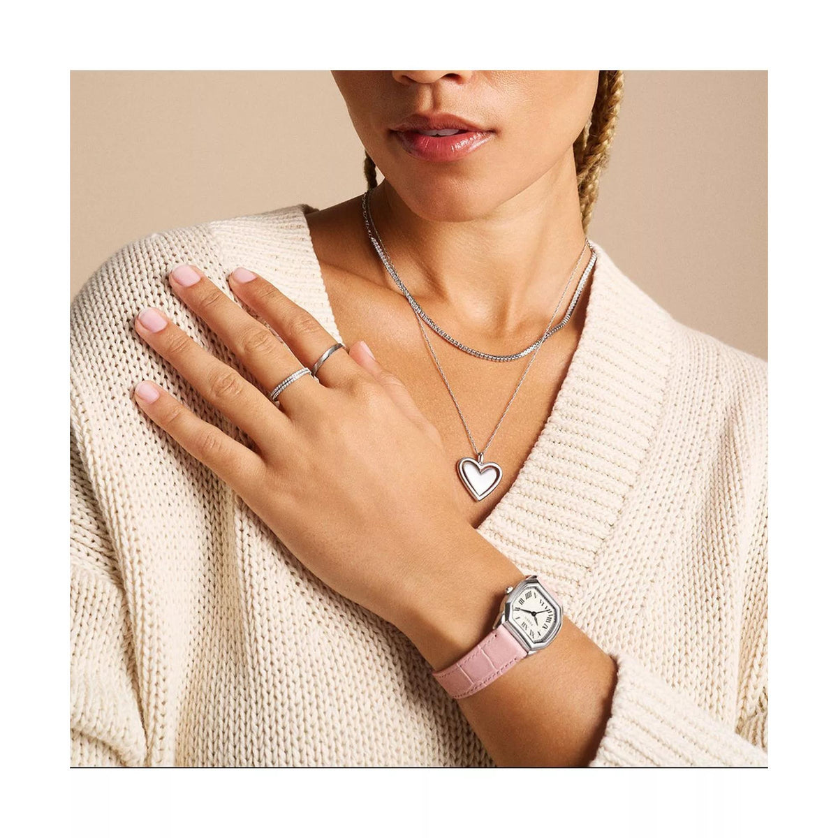 Quartz wristwatch on pink leather strap on model’s wrist with cream dial