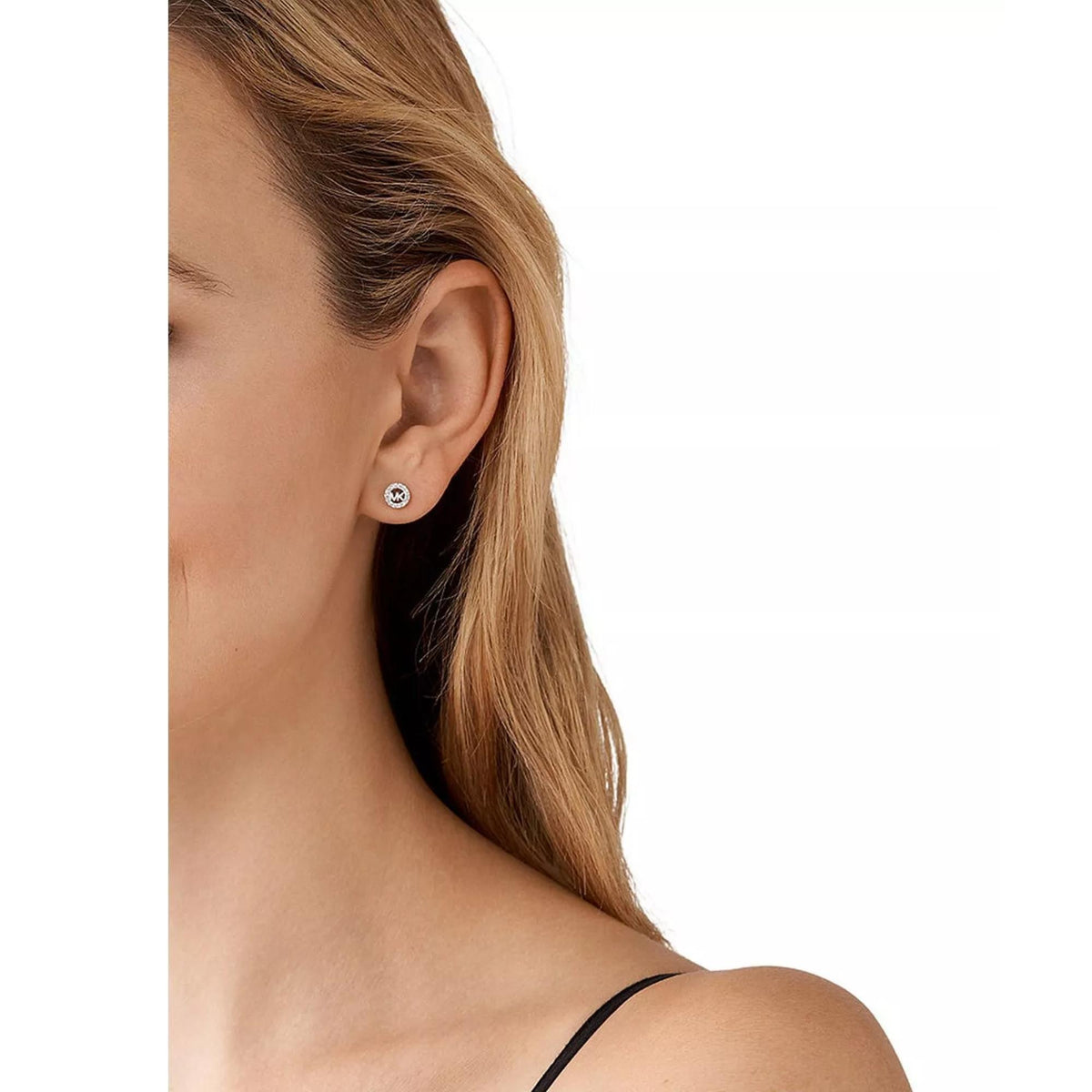 Round sterling silver MK logo stud earring with crystal halo on ear