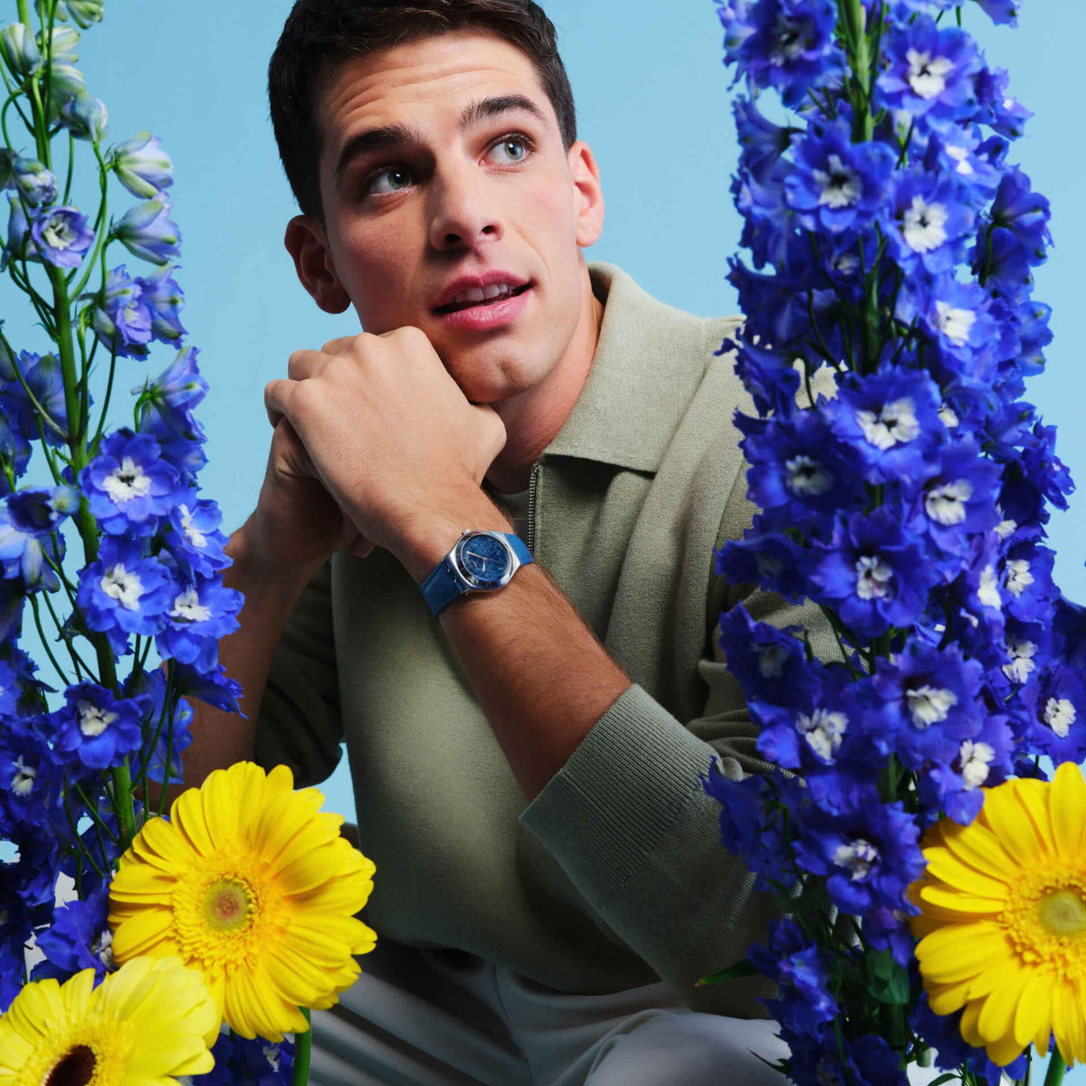 Blue leather strap watch on wrist, blue dial with floral pattern and silver-tone case