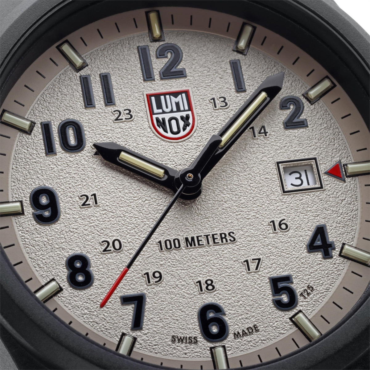 Close-up grey dial watch with logo, luminous hands, and date window at 3