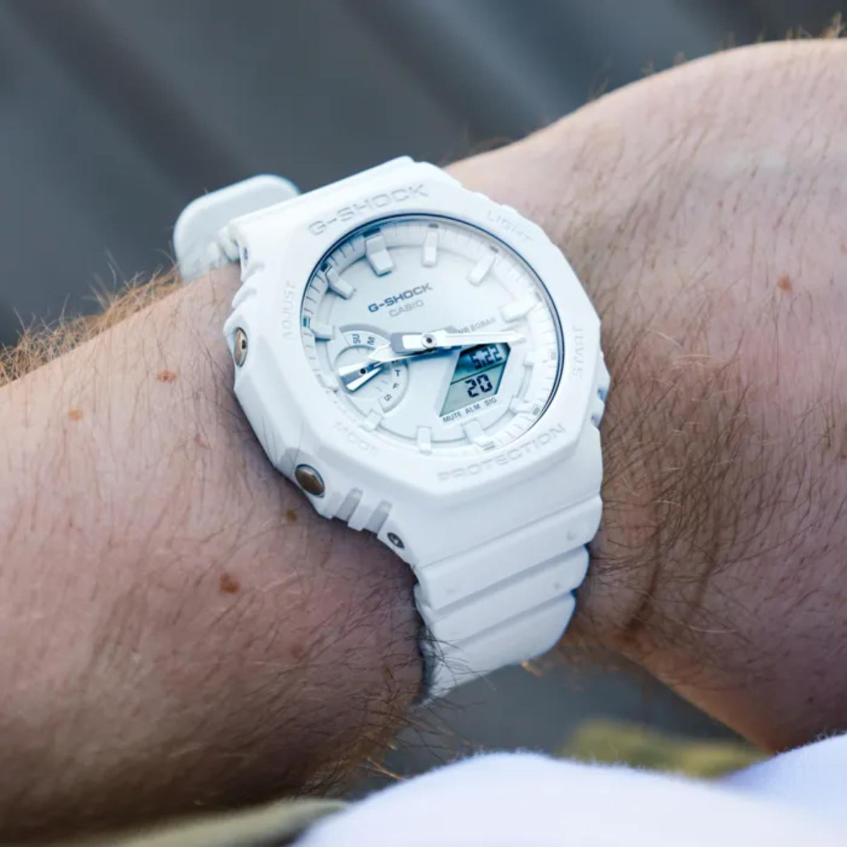 Casio G-Shock on wrist with white resin strap, analog-digital face showing time
