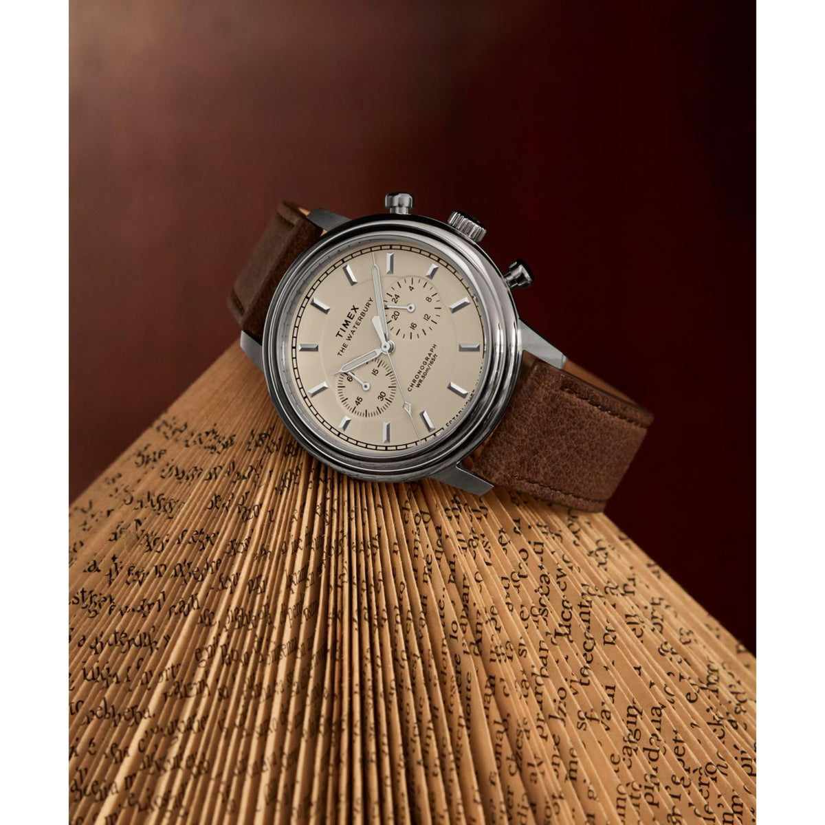 Chronograph quartz watch with cream dial and dark brown leather strap, silver round case.