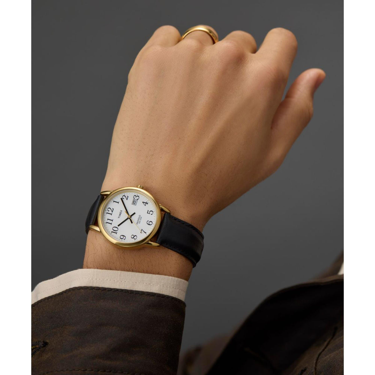 Timex Easy Reader quartz watch on wrist with black leather strap and gold-tone case