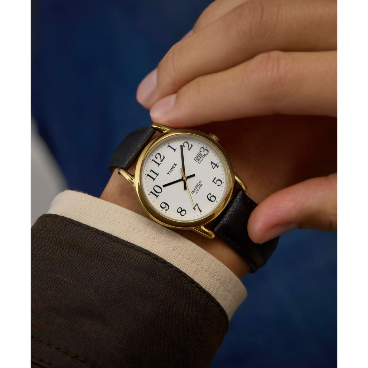 Timex Easy Reader quartz watch worn by hand, white dial with black numerals, gold-tone case