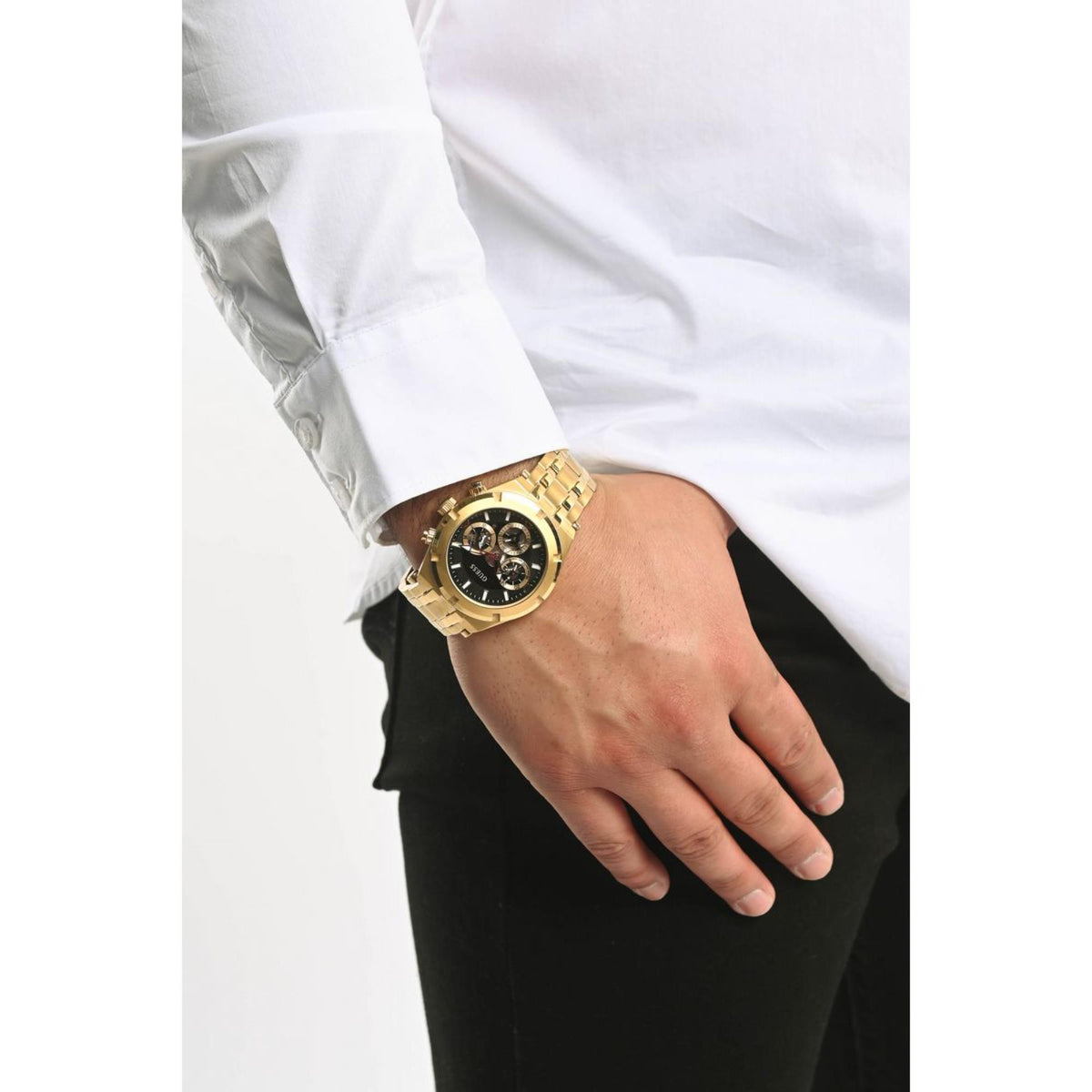 Men's gold-tone stainless steel watch on wrist with black dial and gold bracelet