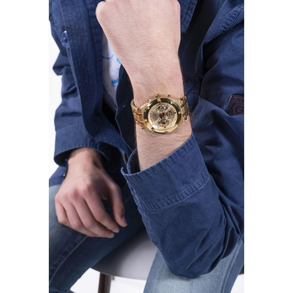 Men's gold-tone stainless steel wristwatch on forearm, champagne skeleton-style dial