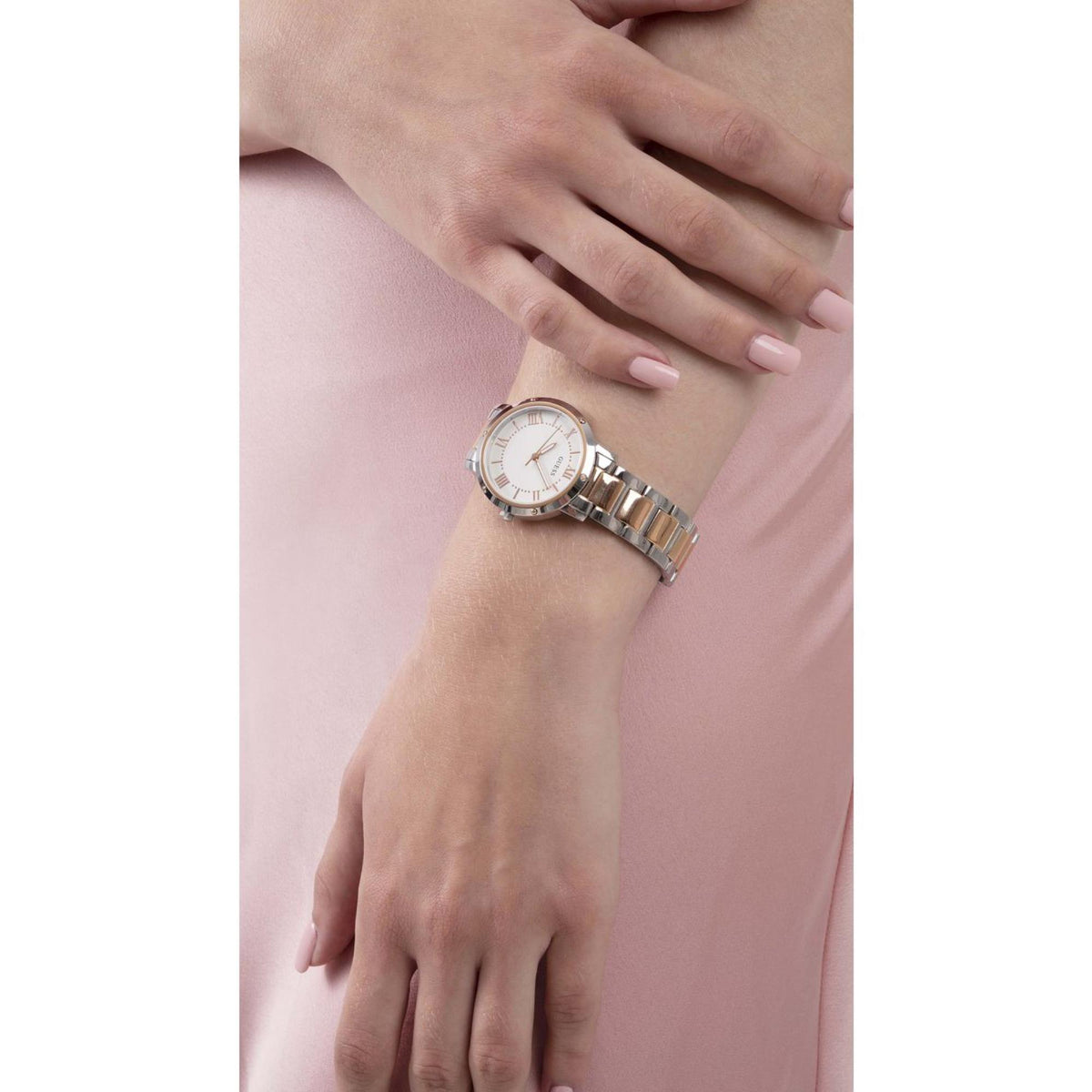 Women’s two-tone wristwatch on wrist, round white dial with gold accents and metal bracelet