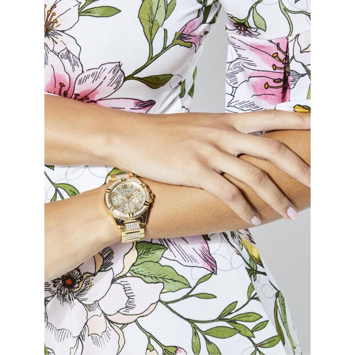 Women’s gold tone watch with sparkling rhinestone bezel and champagne dial on wrist